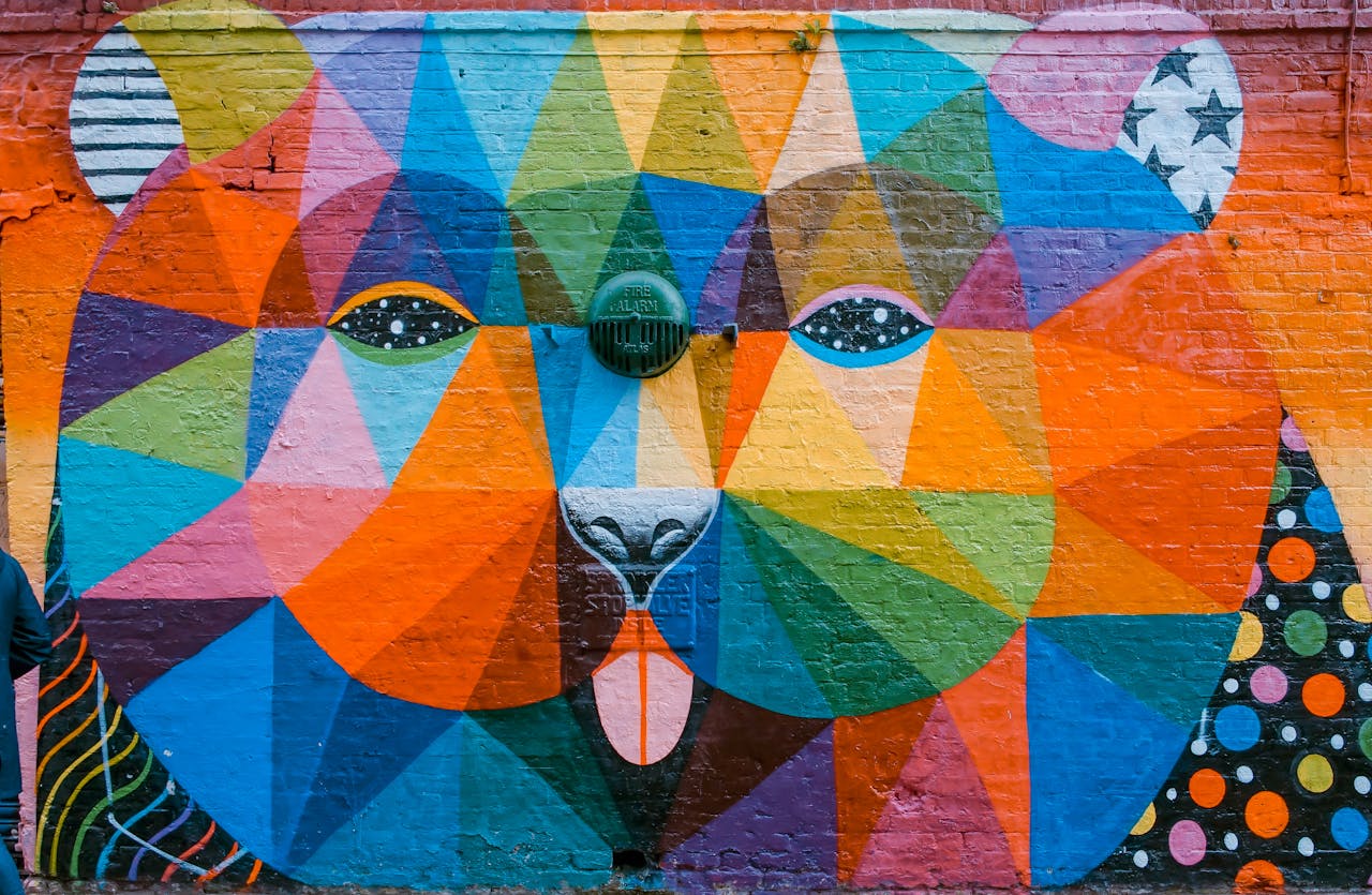 services-03 Vibrant geometric mural of a bear on a brick wall in London, showcasing diverse colors and artistic flair.