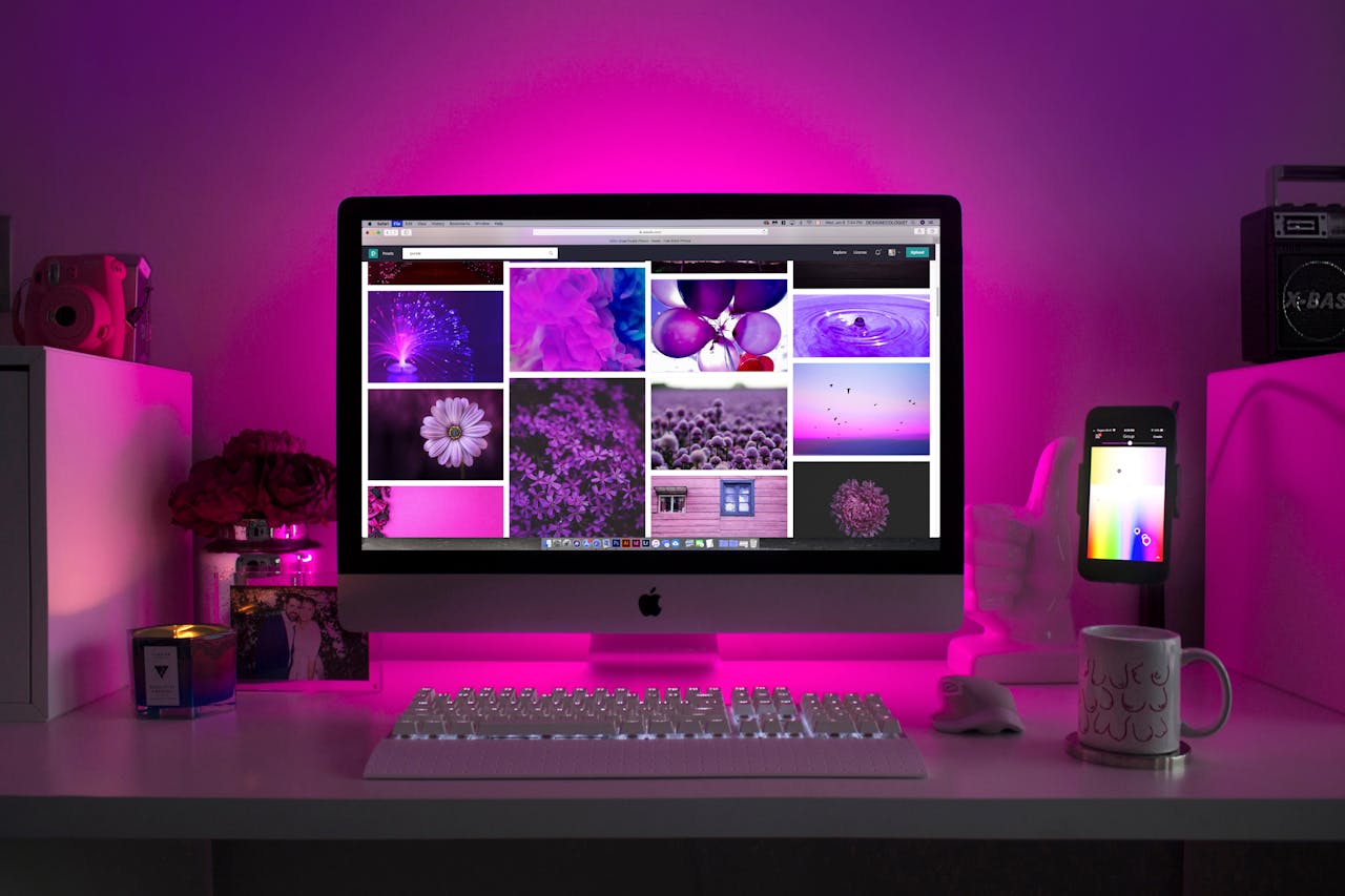 why-choose-us Modern desk setup with neon lighting and a desktop computer displaying colorful images.